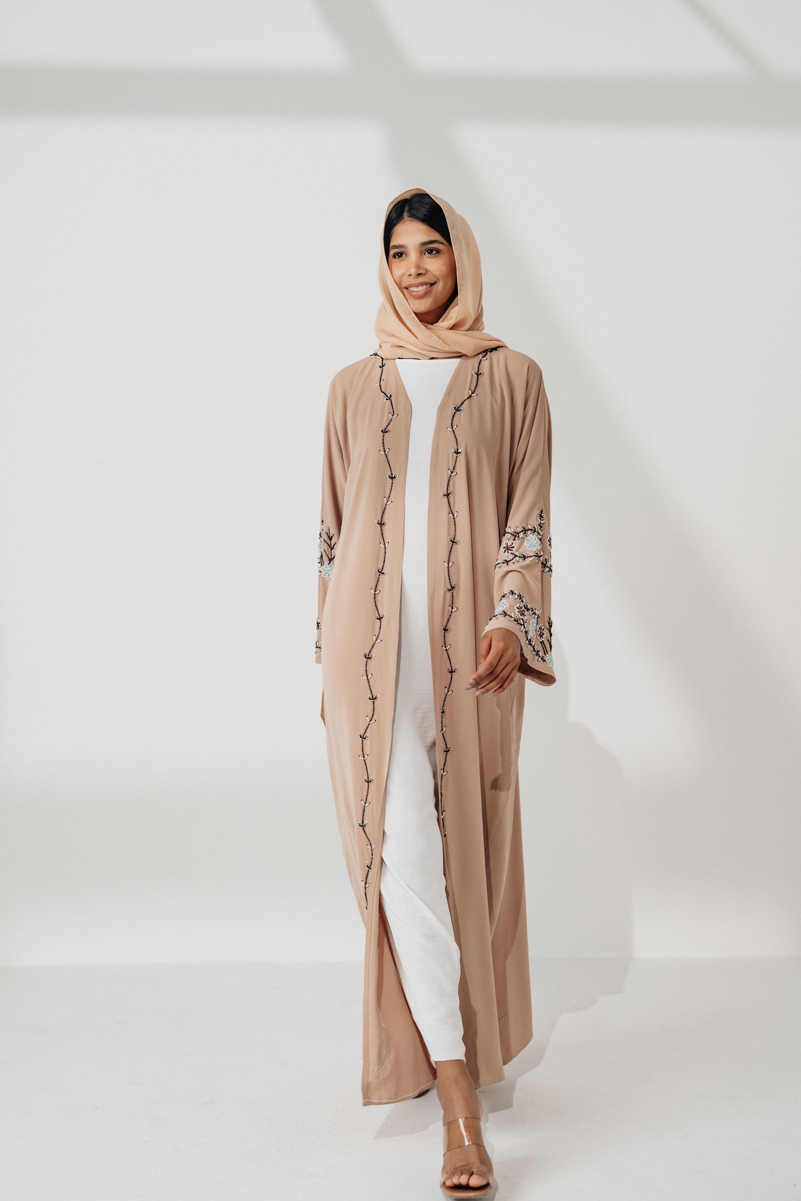 Model in a camel abaya against a clean backdrop