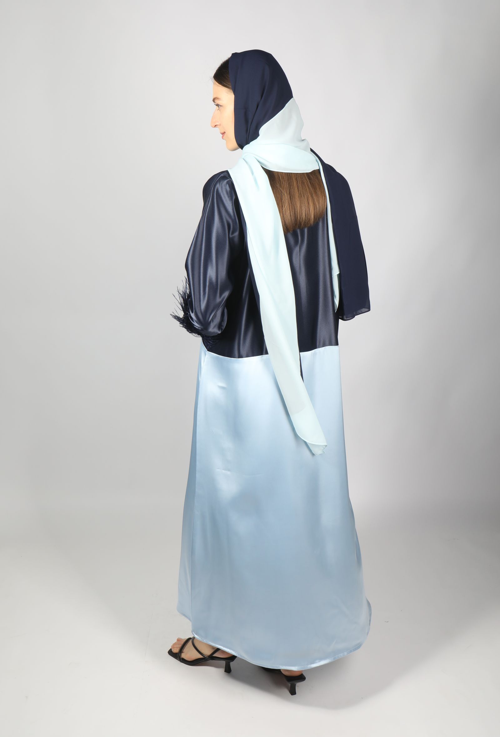 Model in a dark abaya with gold-trimmed cuff
