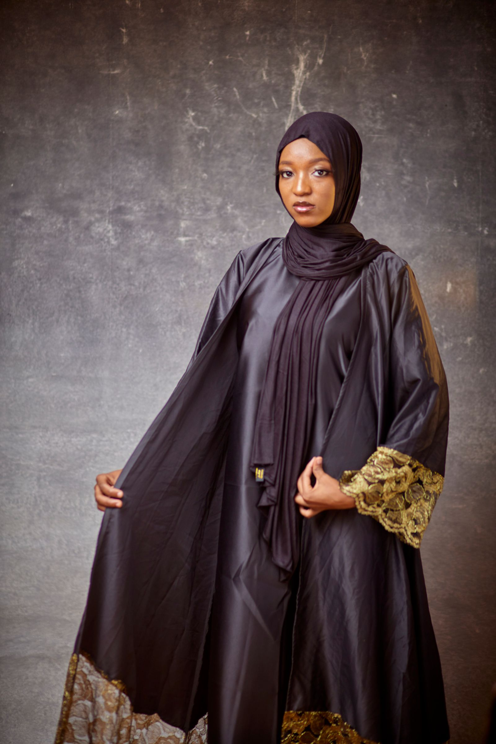 Model in a dark abaya with a finished cuff