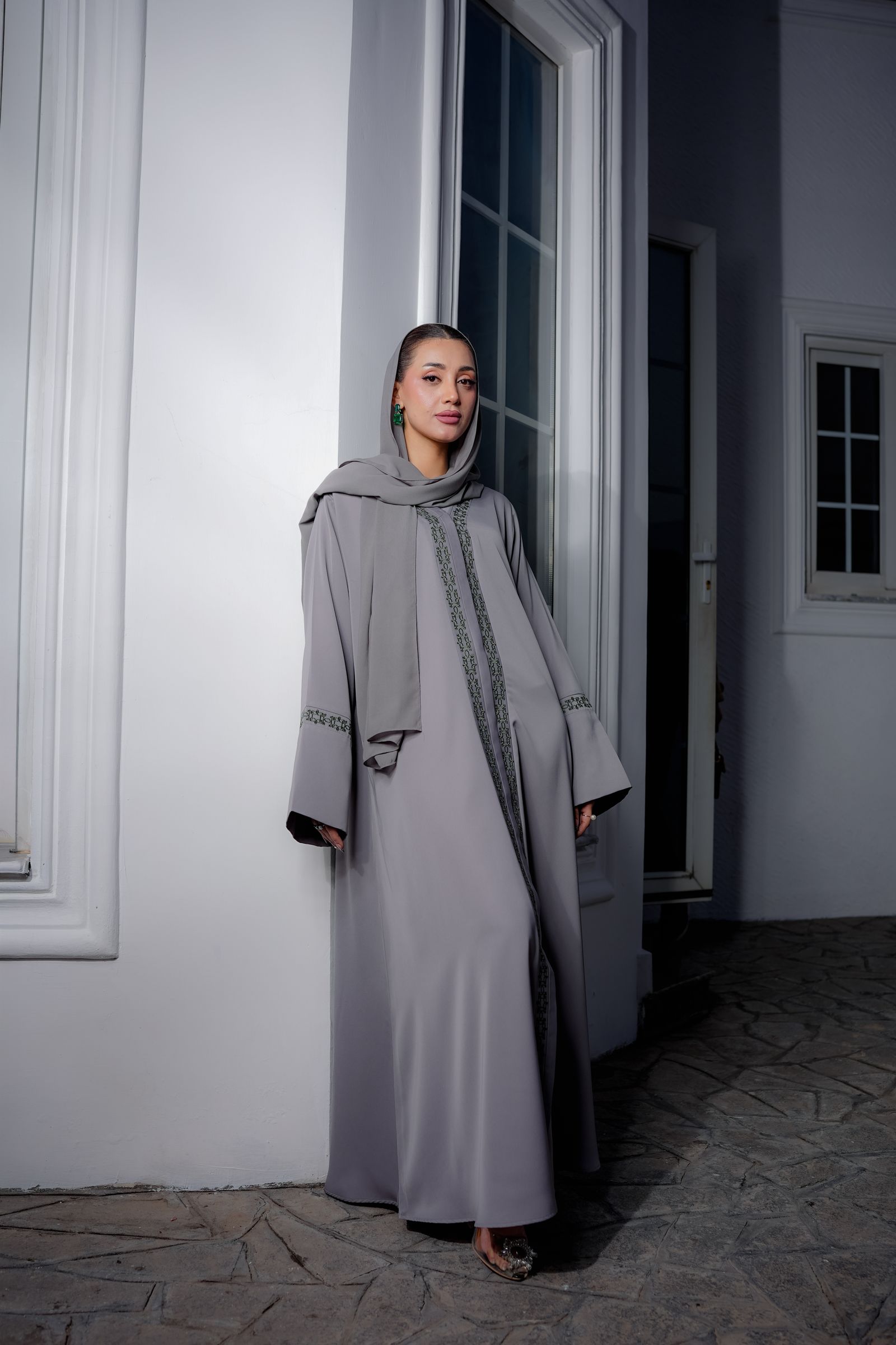 Model in a taupe abaya in a pale architectural setting