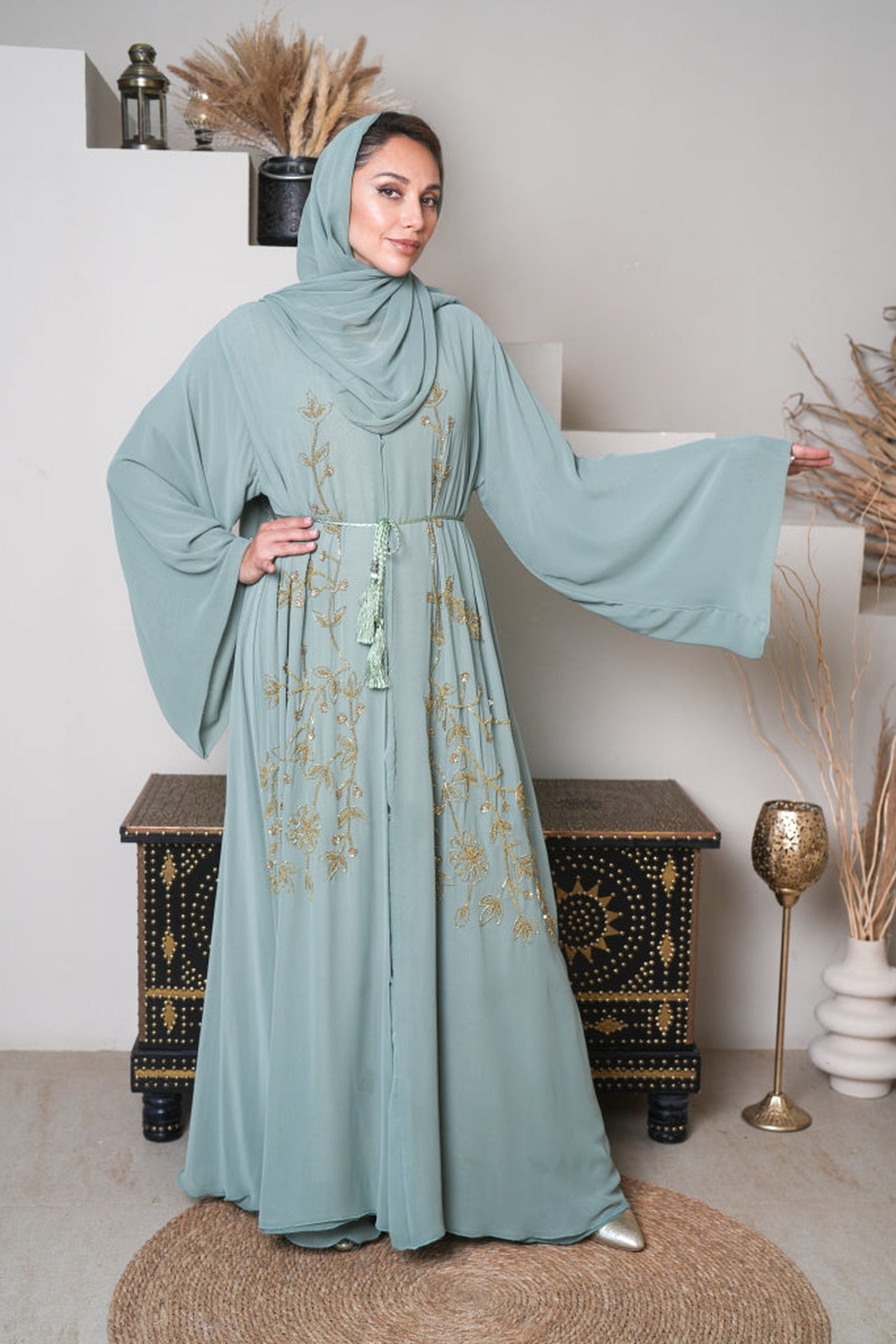Model in a soft sage abaya with a belted waist